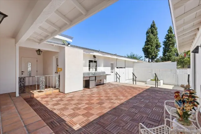 a patio view with a table and chairs and potted plants