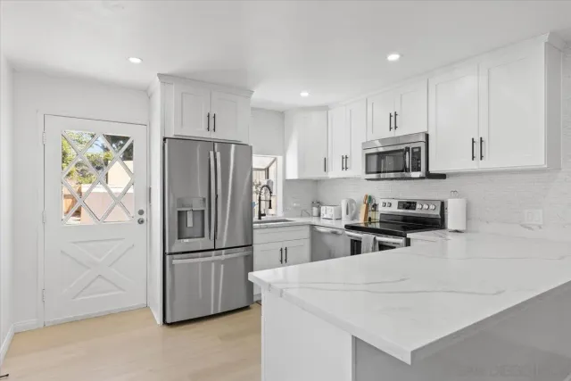 a kitchen with a refrigerator a stove top oven a sink and cabinets