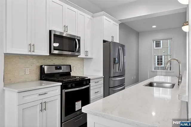 a view of empty room with wooden floor and window