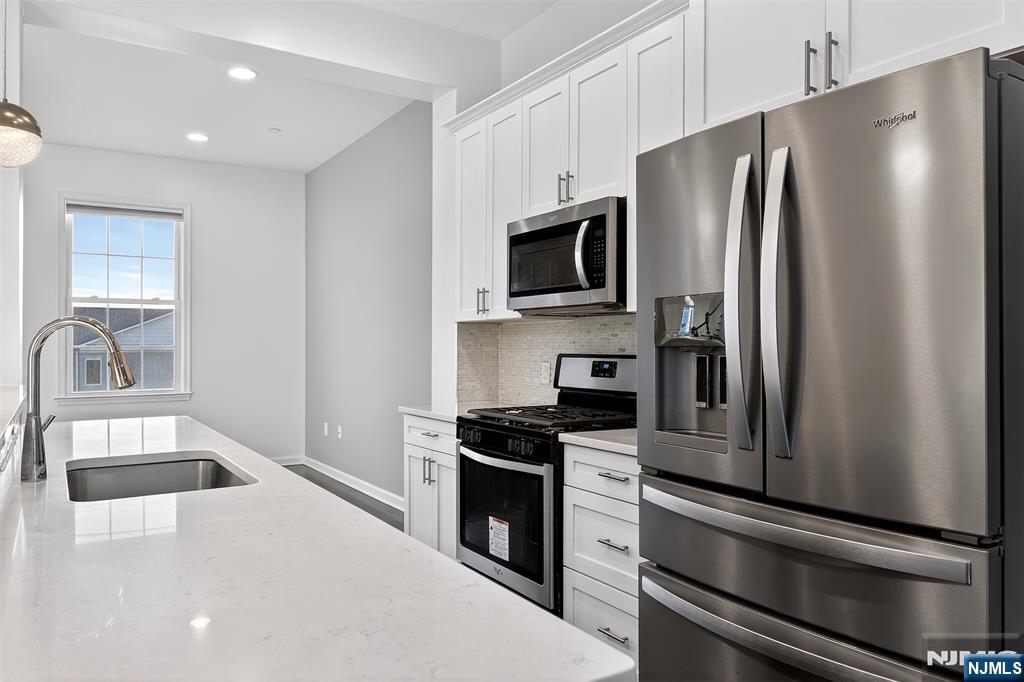 215 Roosevelt Drive Wood-Ridge, NJ 07075 - Photo 13 of 50 a kitchen with a refrigerator sink and stainless steel appliances