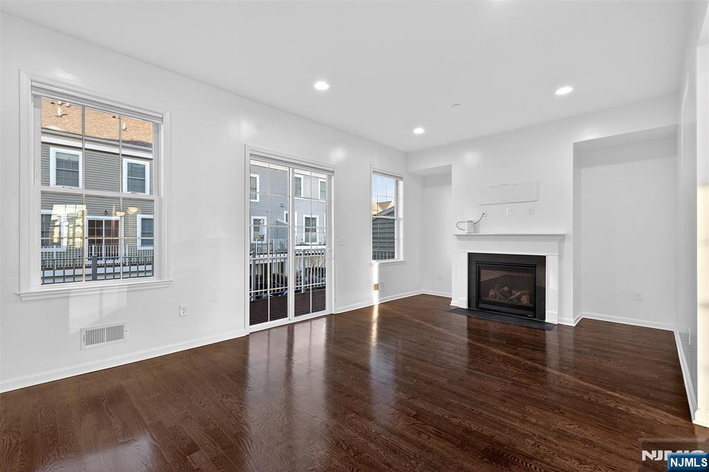 215 Roosevelt Drive Wood-Ridge, NJ 07075 - Photo 16 of 50 a view of an empty room with wooden floor and a window