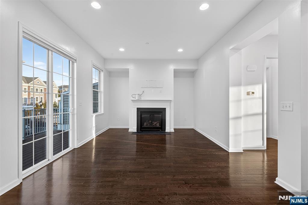 215 Roosevelt Drive Wood-Ridge, NJ 07075 - Photo 17 of 50 a view of an empty room with wooden floor fireplace and a window
