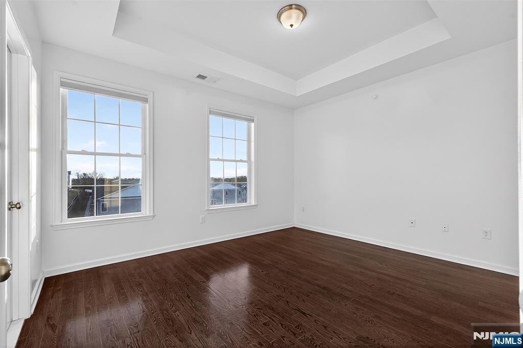 215 Roosevelt Drive Wood-Ridge, NJ 07075 - Photo 26 of 50 an empty room with wooden floor and windows