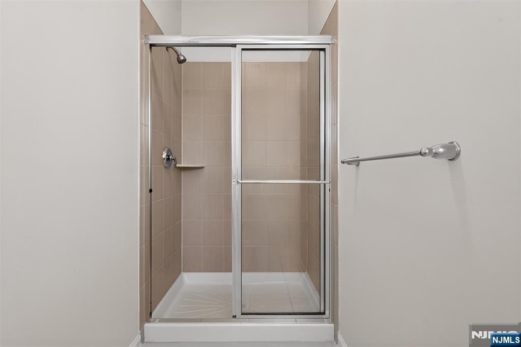 215 Roosevelt Drive Wood-Ridge, NJ 07075 - Photo 29 of 50 a bathroom with a glass shower door