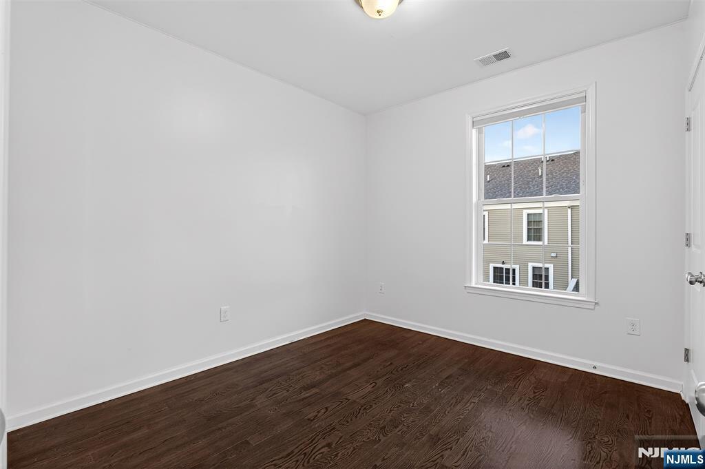 215 Roosevelt Drive Wood-Ridge, NJ 07075 - Photo 32 of 50 an empty room with wooden floor and windows