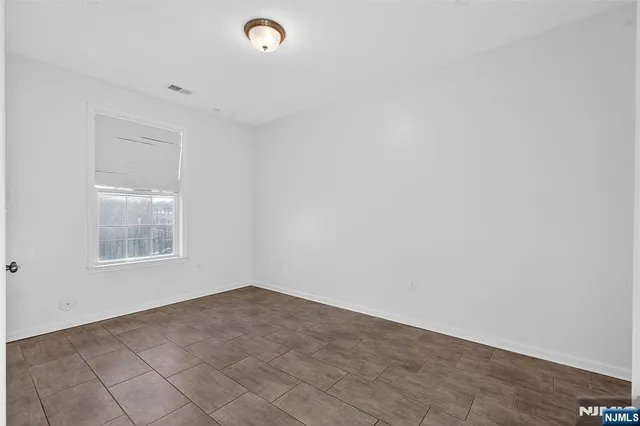 a view of entryway with kitchen and hall with wooden floor