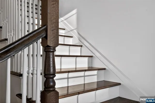 a view of an empty room with wooden floor fireplace and a window
