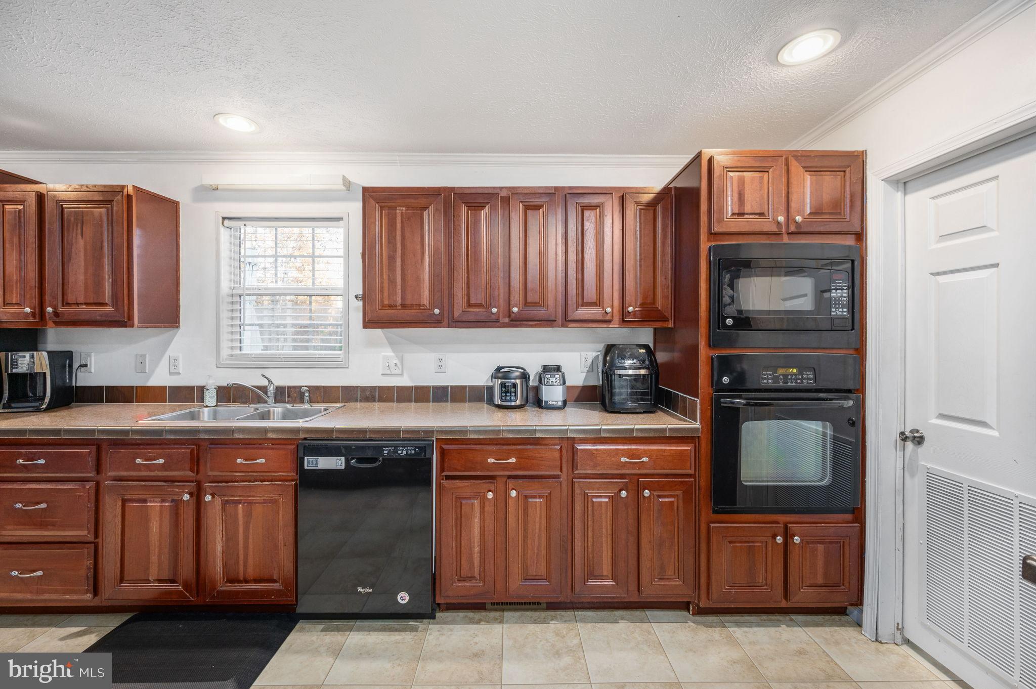 10325 Mill Pond Road Spotsylvania, VA 22551 - Photo 11 of 43 a kitchen with granite countertop wooden cabinets and a stove top oven