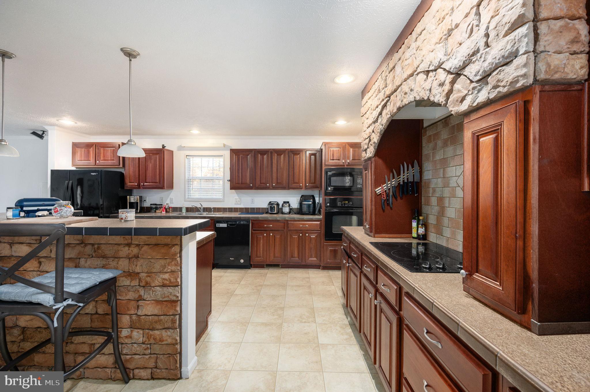 10325 Mill Pond Road Spotsylvania, VA 22551 - Photo 12 of 43 a kitchen with kitchen island granite countertop a sink counter top space appliances and cabinets