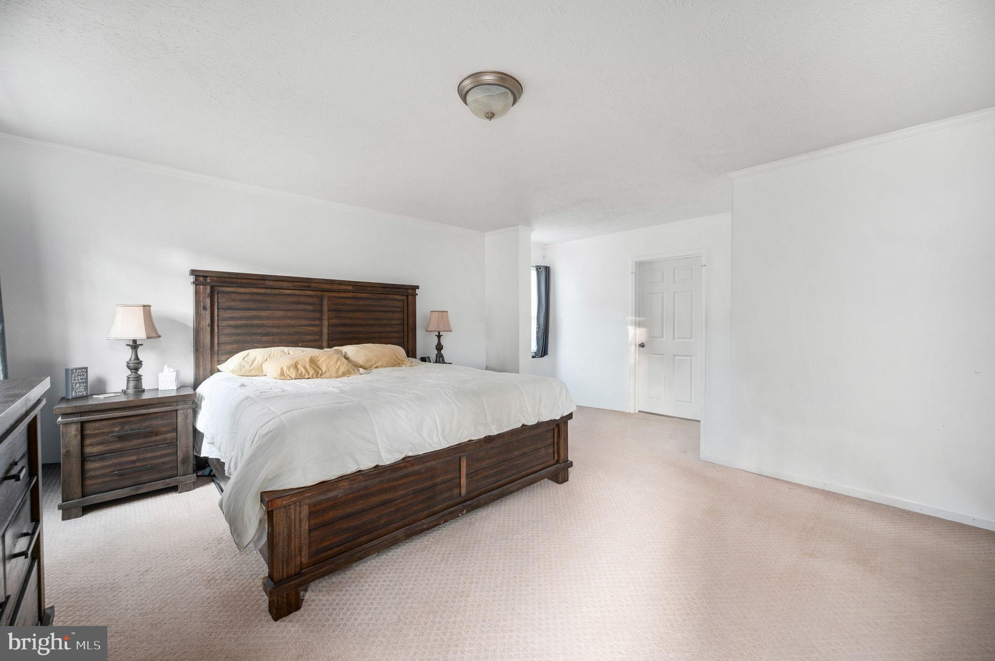 10325 Mill Pond Road Spotsylvania, VA 22551 - Photo 16 of 43 a bed sitting in a bedroom next to a lamp