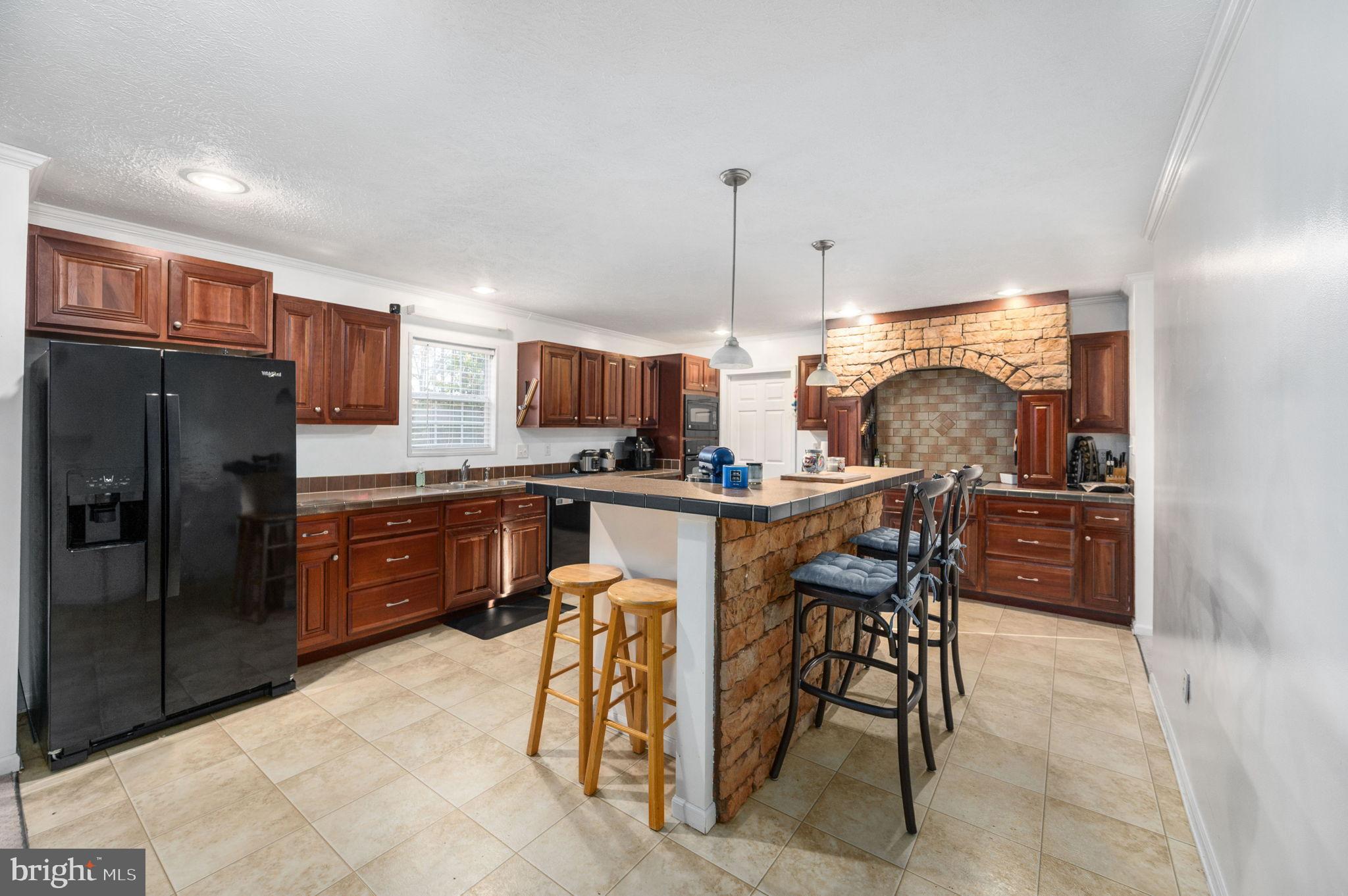 10325 Mill Pond Road Spotsylvania, VA 22551 - Photo 9 of 43 a kitchen with stainless steel appliances kitchen island granite countertop dining table chairs sink and cabinets