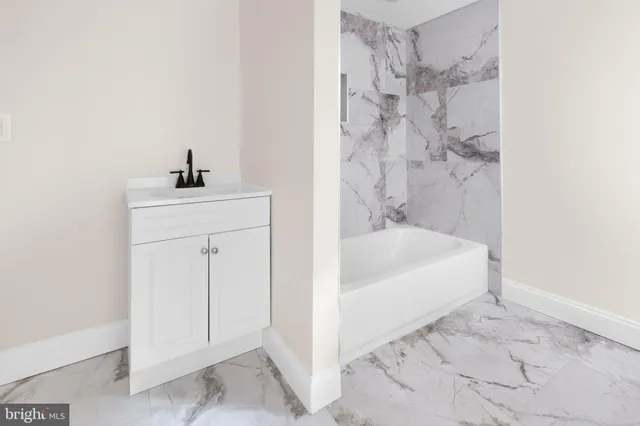 a white bath tub sitting next to a white sink