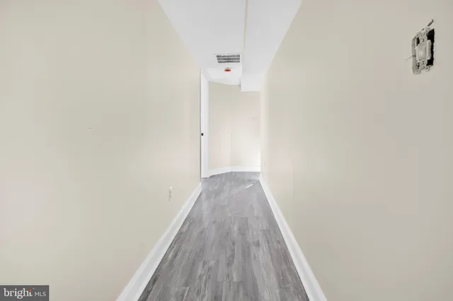 a view of a hallway with wooden floor