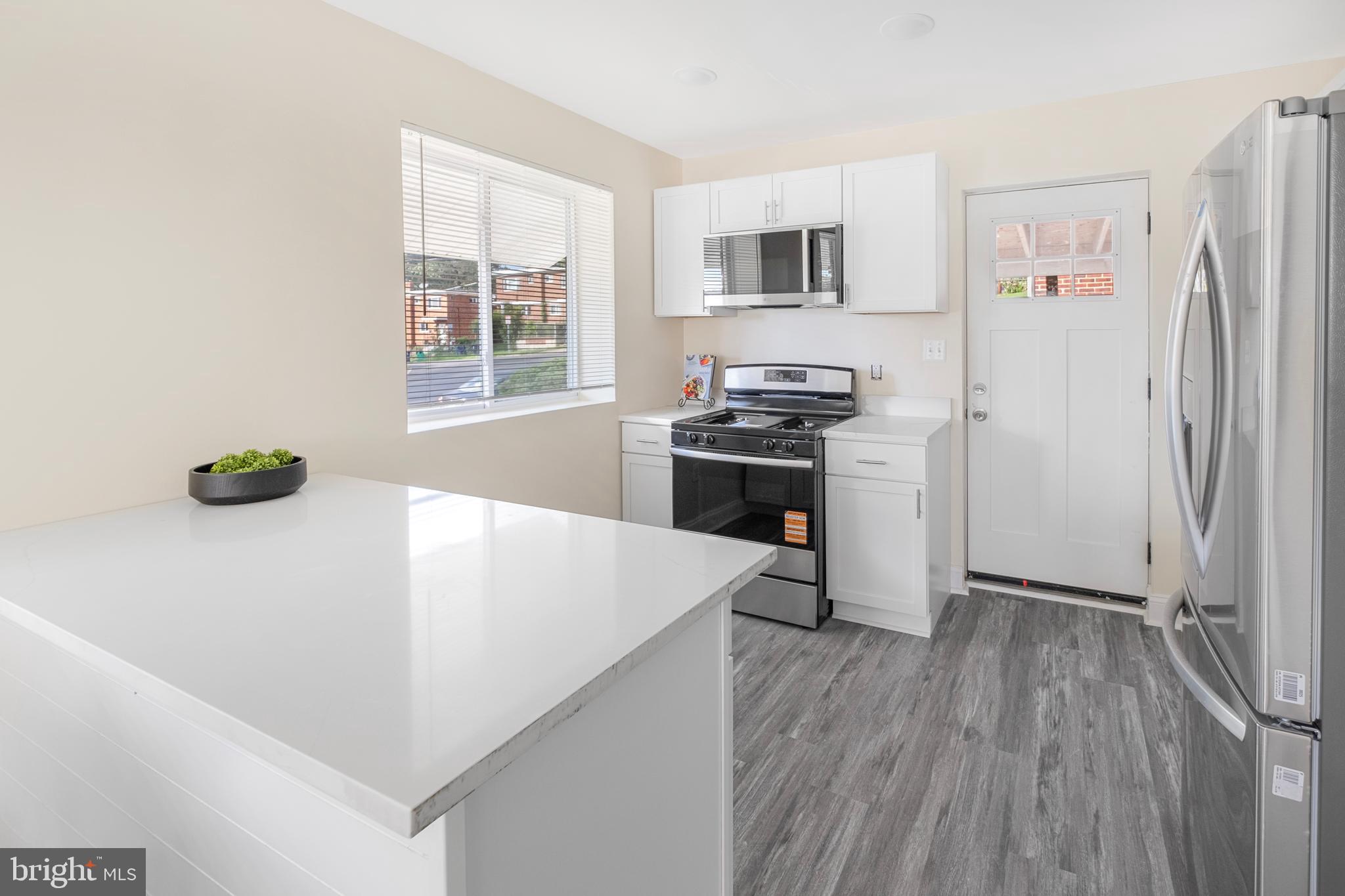 713 Marcy Avenue Oxon Hill, MD 20745 - Photo 5 of 24 a kitchen with stainless steel appliances a white refrigerator a stove a sink and a microwave