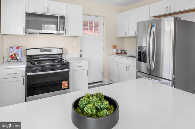 a kitchen with a stove a refrigerator and a sink
