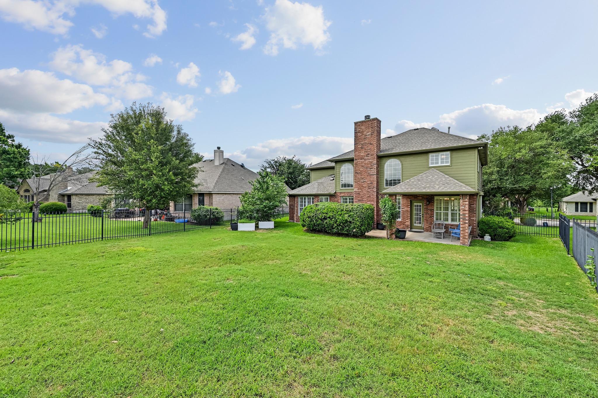 2408 Amen Corner Road Pflugerville, TX 78660 - Photo 37 of 40 Expansive green lawn with a black metal fence enclosing the property
