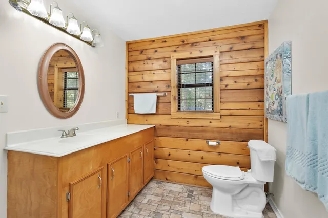 a bathroom with a toilet a sink and a mirror