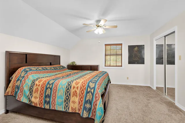 a bedroom with a large bed and a chandelier