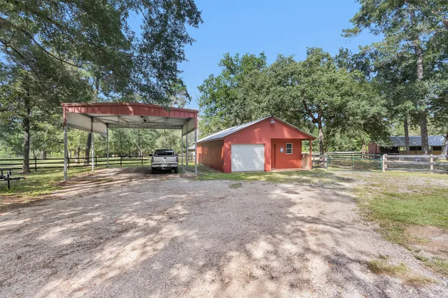 a view of a barn with wooden fence