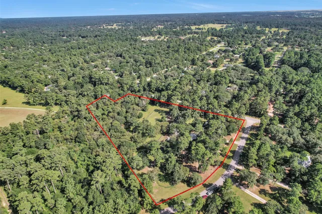 an aerial view of a houses with a lush green hillside