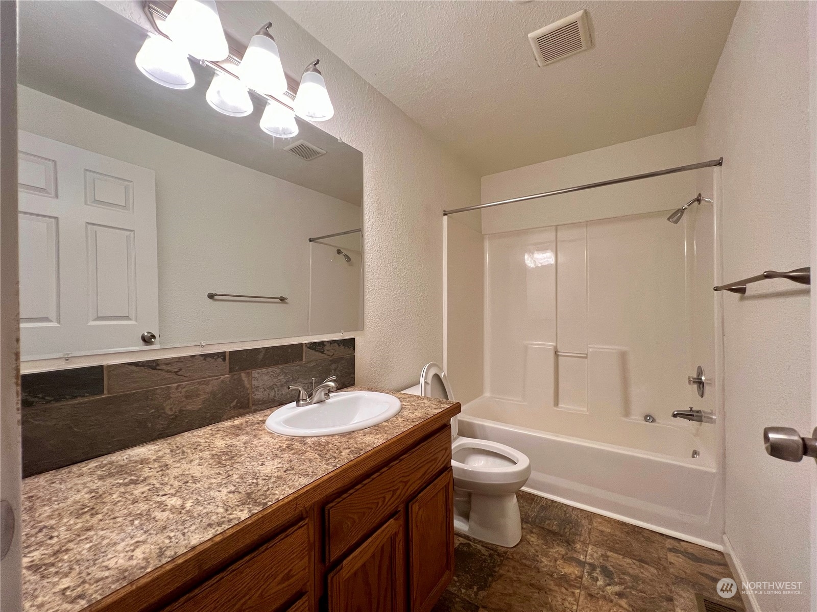 1951 Southeast Van Skiver Road Port Orchard, WA 98367 - Photo 17 of 30 a bathroom with a granite countertop sink a toilet and bathtub