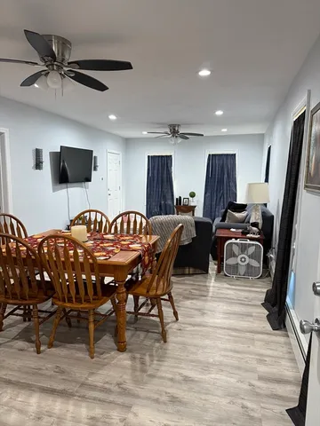 a living room with furniture a flat screen tv and a table