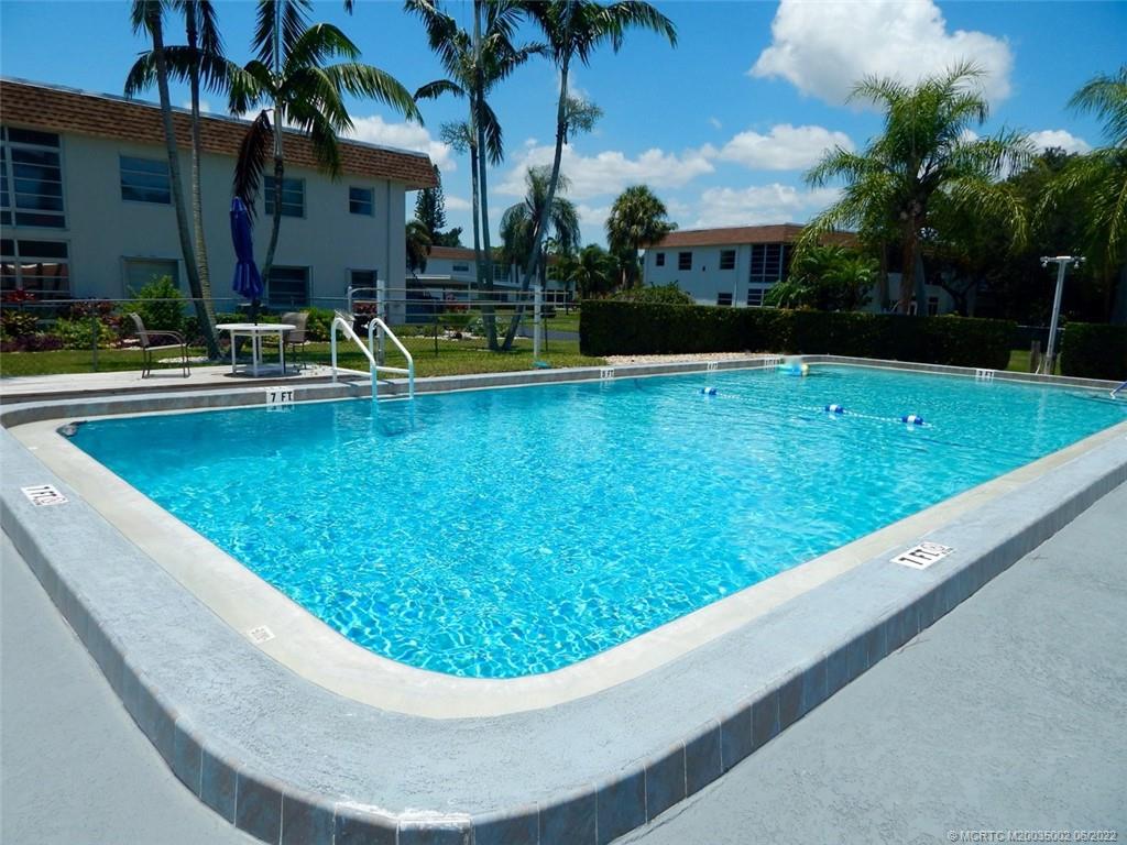 a view of swimming pool with outdoor seating and house in the background