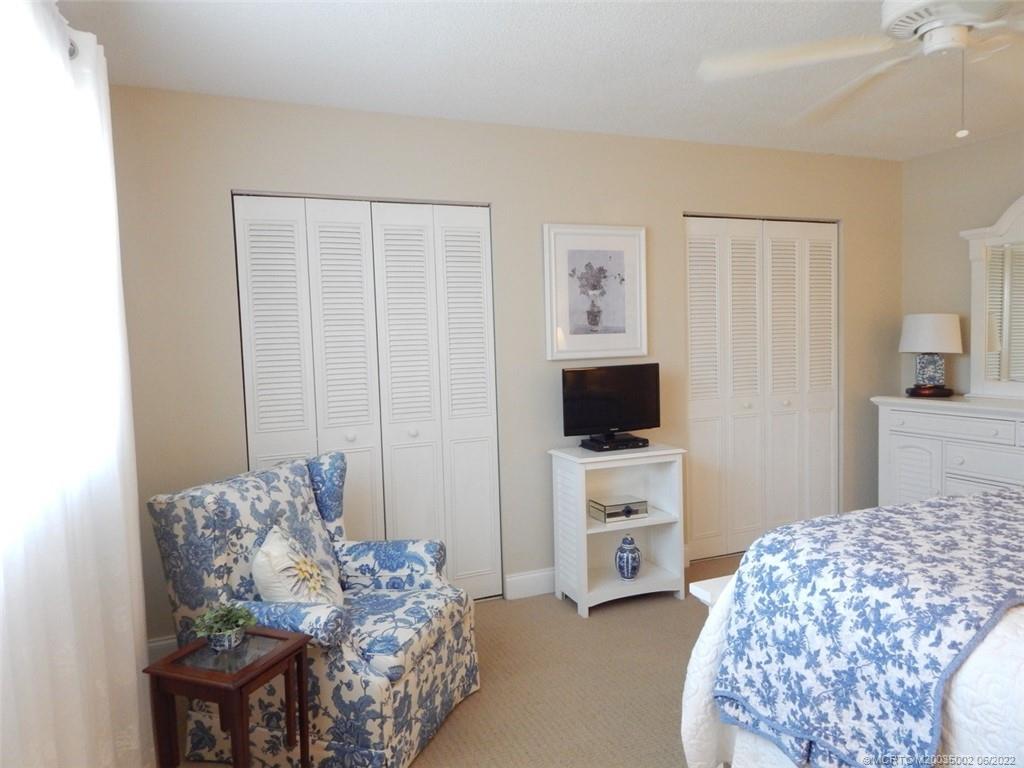 2950 Southeast Ocean Boulevard, Unit 74 Stuart, FL 34996 - Photo 15 of 39 a bedroom with furniture and a flat screen tv