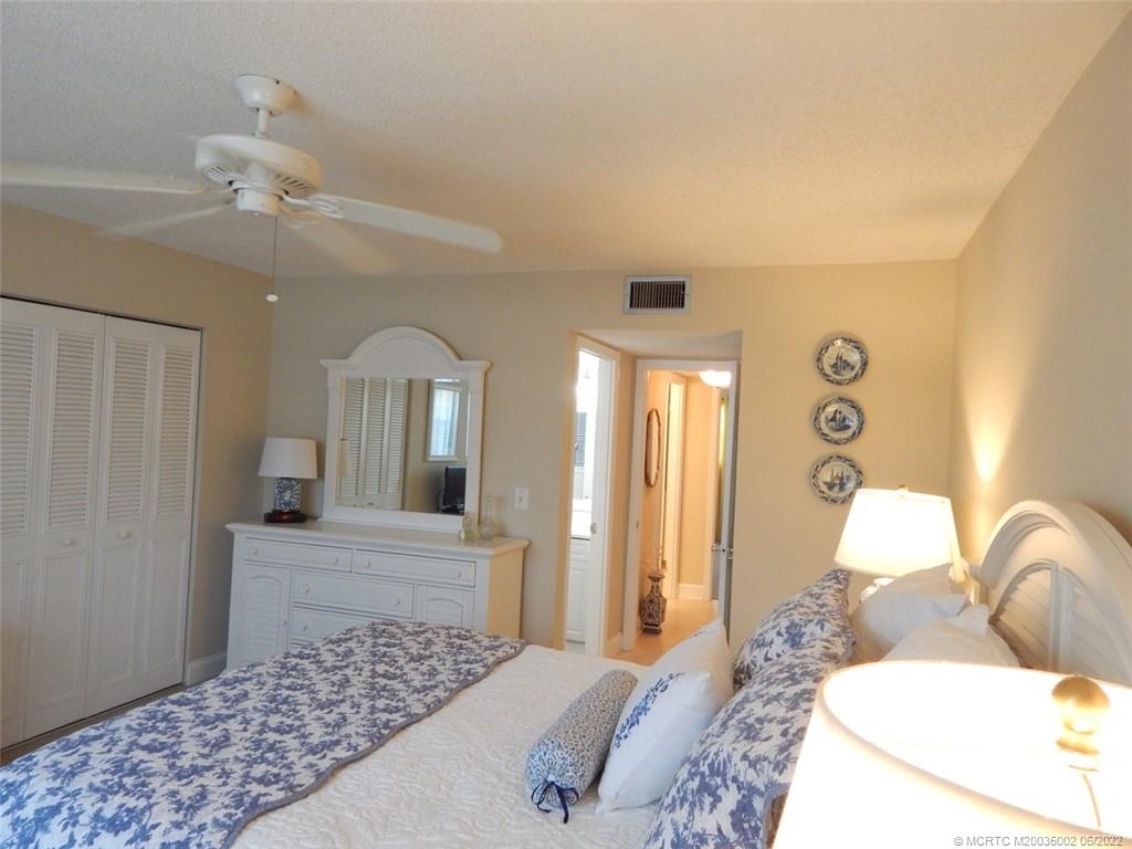 2950 Southeast Ocean Boulevard, Unit 74 Stuart, FL 34996 - Photo 16 of 39 a bedroom with a large bed and a chandelier