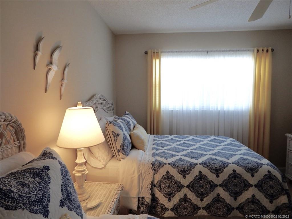 2950 Southeast Ocean Boulevard, Unit 74 Stuart, FL 34996 - Photo 25 of 39 a bedroom with a bed and a lamp
