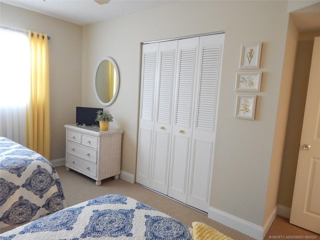 2950 Southeast Ocean Boulevard, Unit 74 Stuart, FL 34996 - Photo 26 of 39 a bedroom with a bed and a mirror