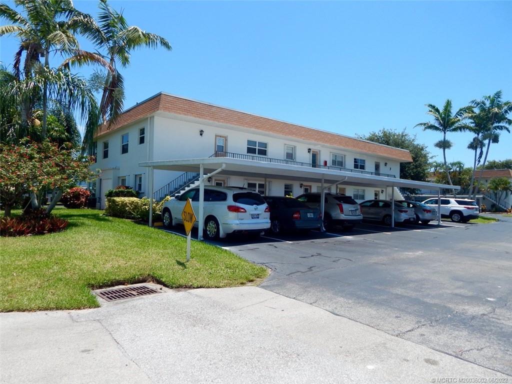 2950 Southeast Ocean Boulevard, Unit 74 Stuart, FL 34996 - Photo 32 of 39 a car parked in front of a building with parked cars