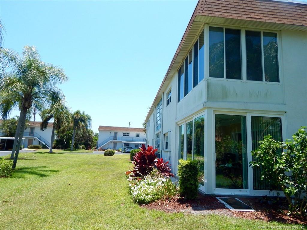 2950 Southeast Ocean Boulevard, Unit 74 Stuart, FL 34996 - Photo 36 of 39 a front view of a house with a yard and potted plants