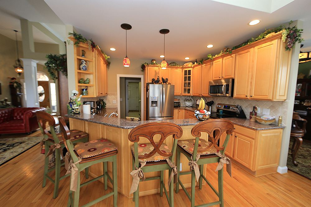 521 Competition Road Raleigh, NC 27603 - Photo 7 of 25 Gracious kitchen with custom 42" cabinetry and rope trim. Solid surface countertops with ceramic backsplash. Maytag SS appliances, roll out cabinetry. Kitchen