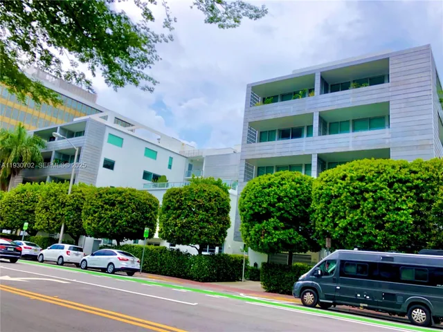 a car parked in front of a building with trees