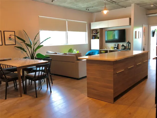 a kitchen with stainless steel appliances granite countertop a sink and a living room