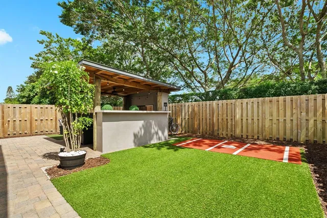 a view of a backyard with a small cabin and wooden fence