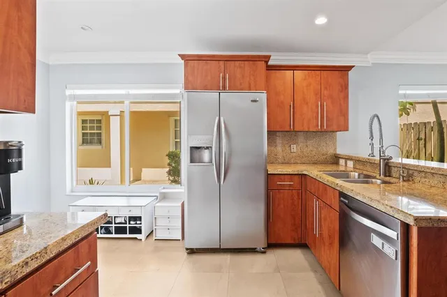 a kitchen with stainless steel appliances granite countertop a refrigerator and a stove top oven