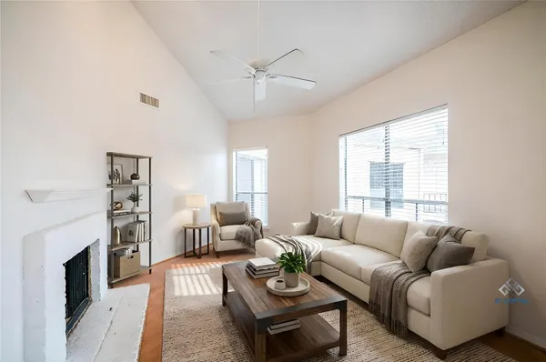 a living room with furniture a fireplace and a large window