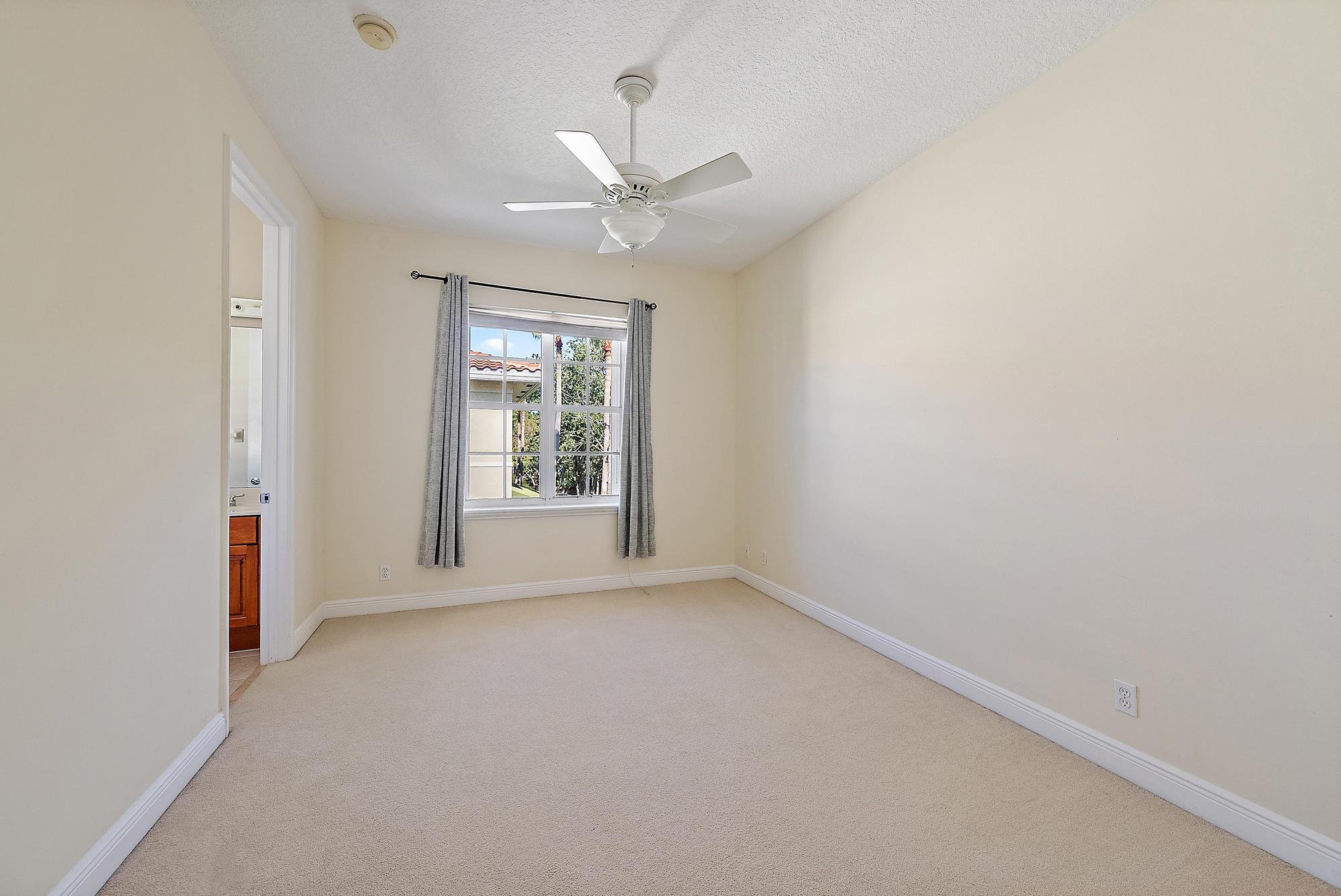 141 Morning Dew Circle Jupiter, FL 33458 - Photo 12 of 22 an empty room with chandelier fan and windows
