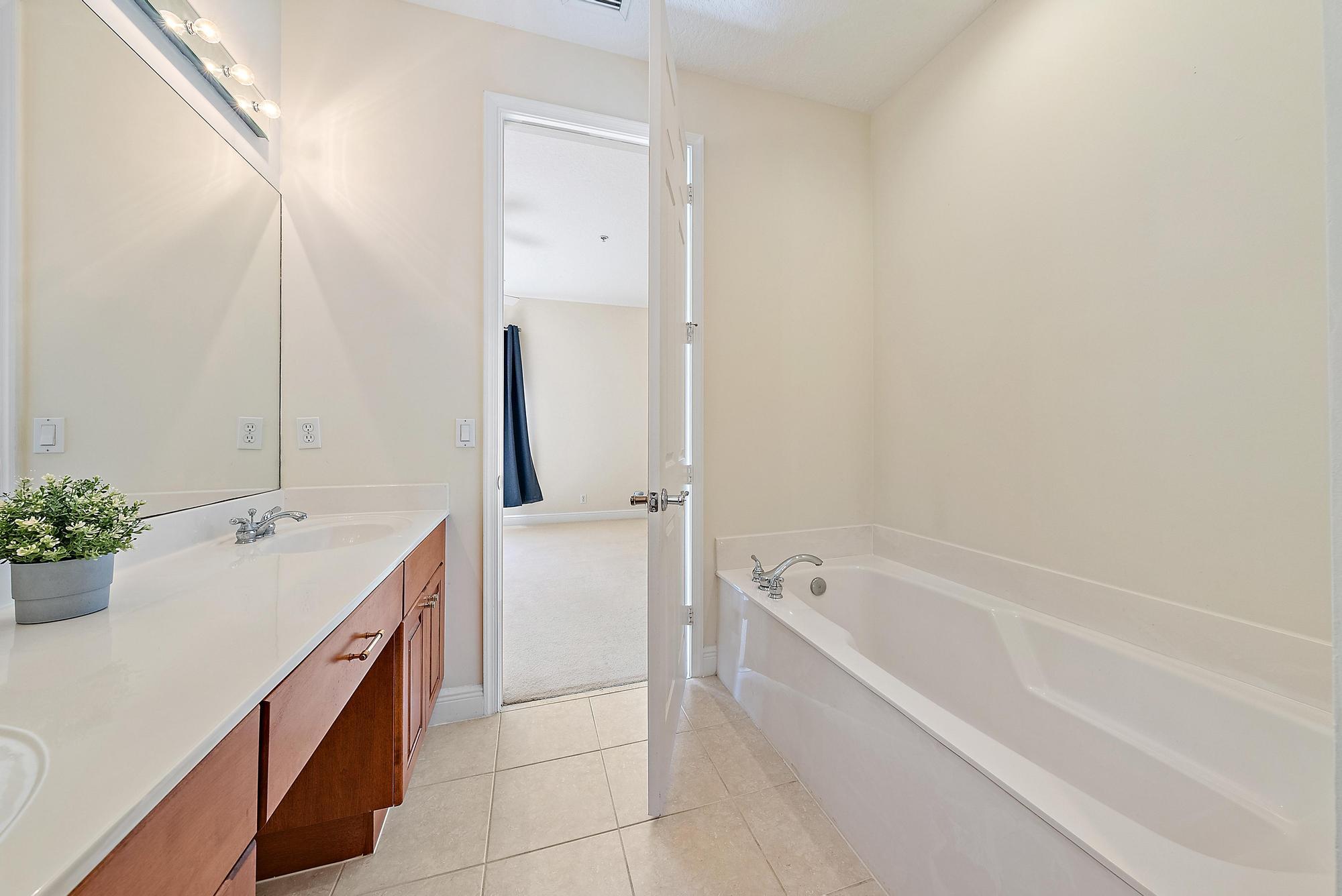 141 Morning Dew Circle Jupiter, FL 33458 - Photo 17 of 22 a spacious bathroom with a bathtub sink and mirror