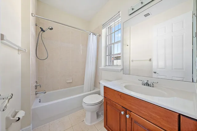 a bathroom with a granite countertop sink a toilet and shower