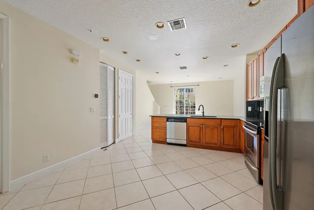 a large white kitchen with a sink and refrigerator