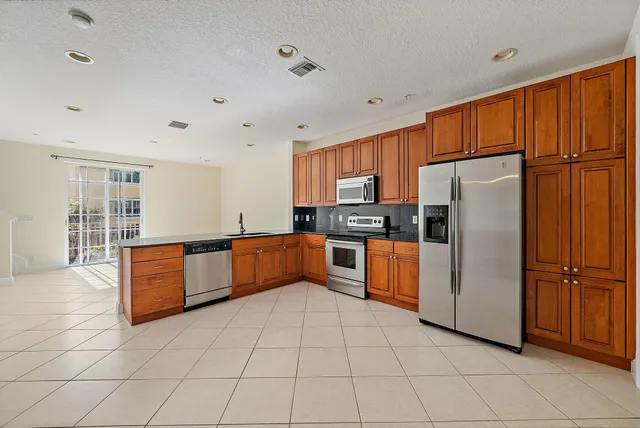 a kitchen with stainless steel appliances a refrigerator and a stove top oven