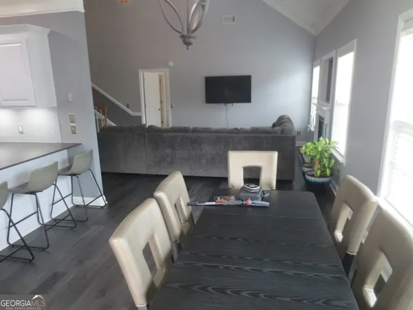 a view of a hallway with wooden floor and chandelier
