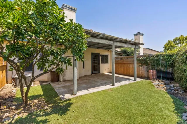a view of a house with backyard and tree
