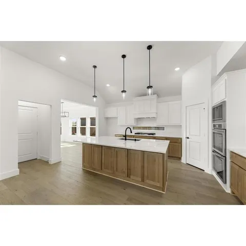 a kitchen with kitchen island a counter top space a sink stainless steel appliances and cabinets