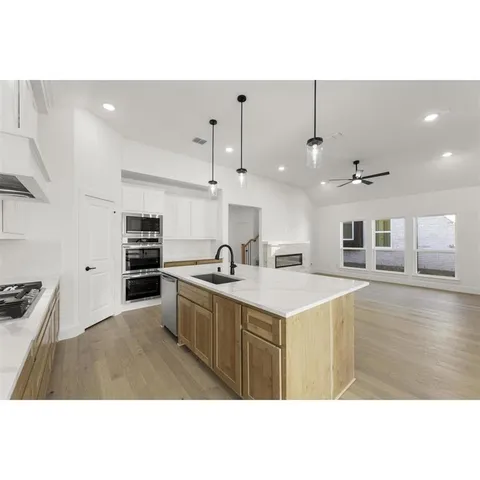 a kitchen with kitchen island a sink counter top space and stainless steel appliances