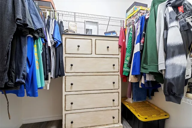 a view of walk in closet with clothes and shoes