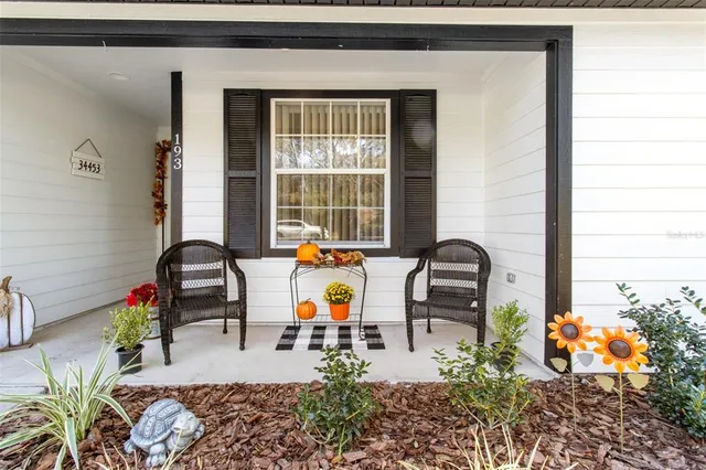 a dining table with potted plants in front of it